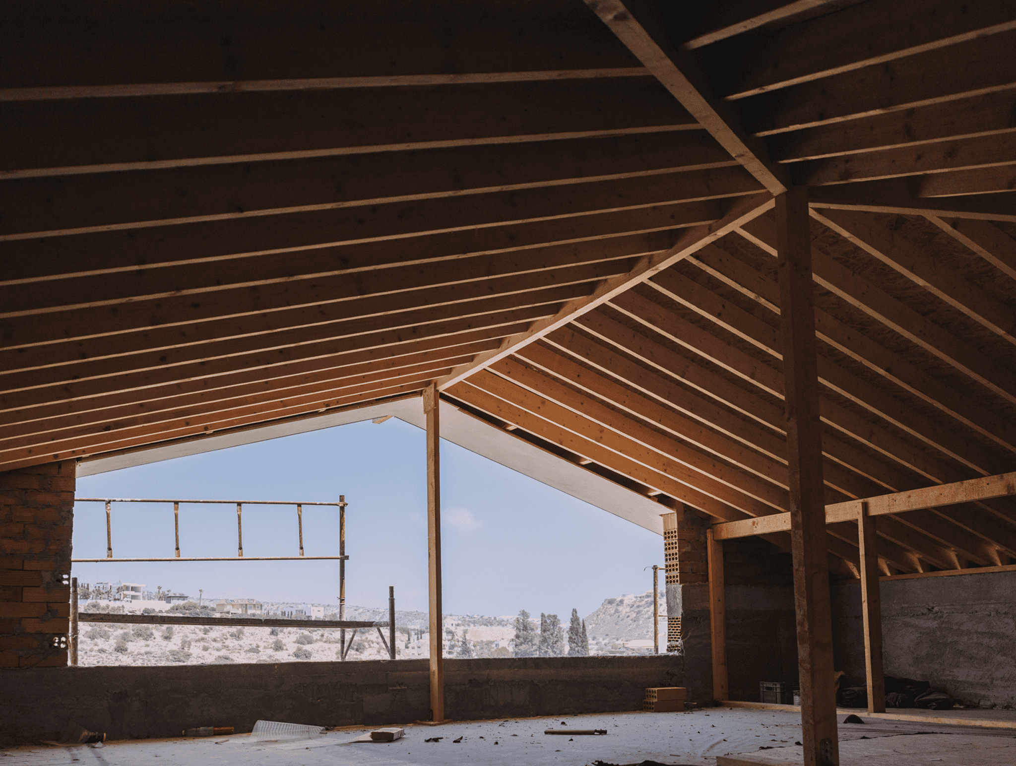 AP Home during construction, showing timber roof framing and open views.